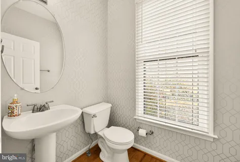 a kitchen with stainless steel appliances kitchen island a refrigerator sink and white cabinets