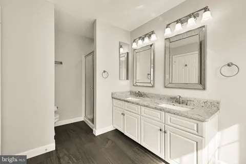 a spacious bathroom with a double vanity sink tub double mirror and window
