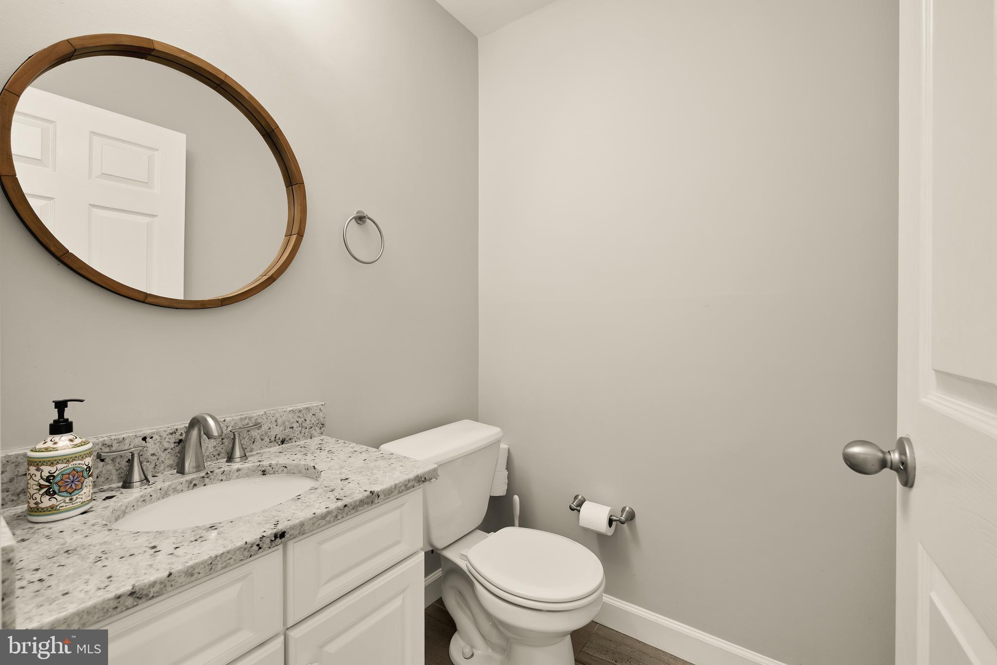 3015 Fallswood Glen Court Falls Church, VA 22044 - Photo 30 of 36 a bathroom with a granite countertop toilet a sink and a mirror