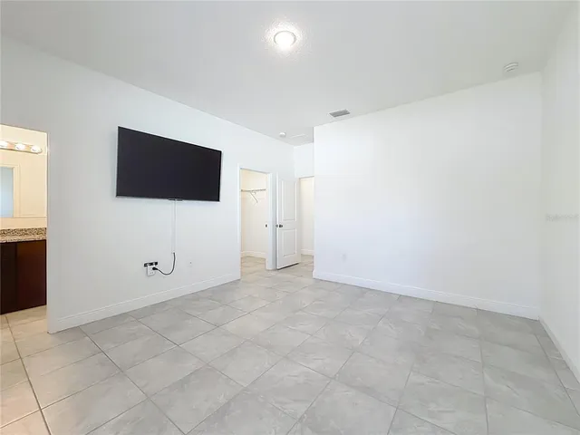 an empty room with windows and fireplace