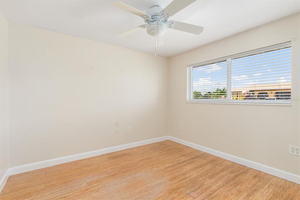 703 Spring Lake Boulevard Northwest Port Charlotte, FL 33952 - Photo 19 of 36 an empty room with wooden floor and windows