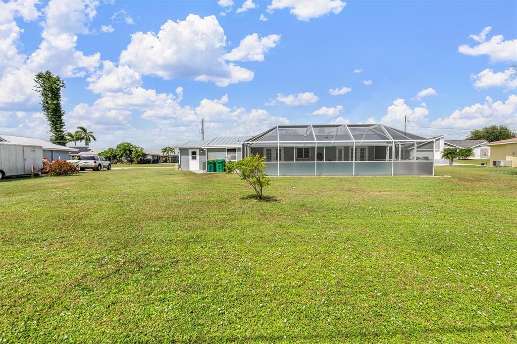 703 Spring Lake Boulevard Northwest Port Charlotte, FL 33952 - Photo 29 of 36 a view of a house with a big yard and large trees