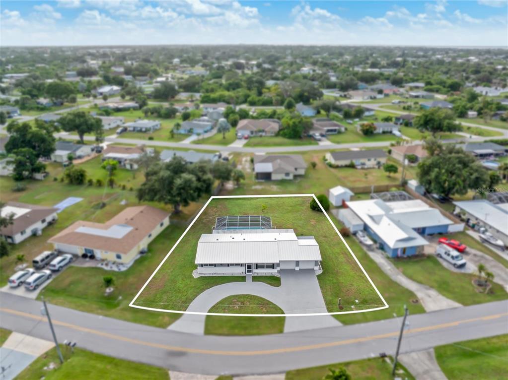 703 Spring Lake Boulevard Northwest Port Charlotte, FL 33952 - Photo 36 of 36 an aerial view of a tennis ground and large trees