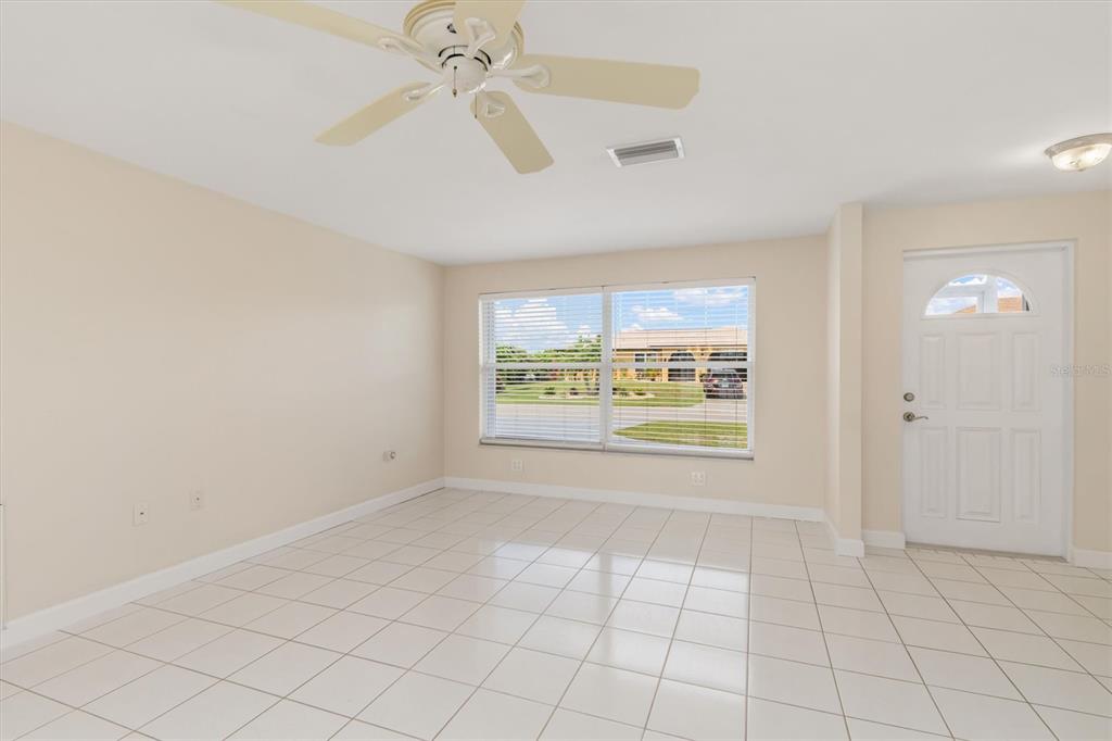 703 Spring Lake Boulevard Northwest Port Charlotte, FL 33952 - Photo 6 of 36 an empty room with windows and fan