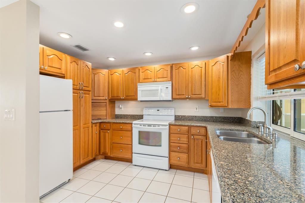 703 Spring Lake Boulevard Northwest Port Charlotte, FL 33952 - Photo 9 of 36 a kitchen with a stove sink cabinets and refrigerator