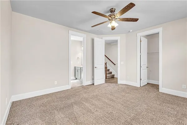 an empty room with ceiling fan and window