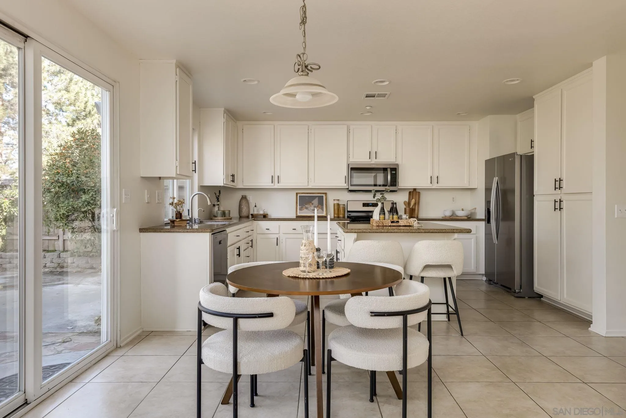 1589 Laurel Circle Vista, CA 92081 - Photo 7 of 31 a kitchen with stainless steel appliances a dining table chairs refrigerator and sink