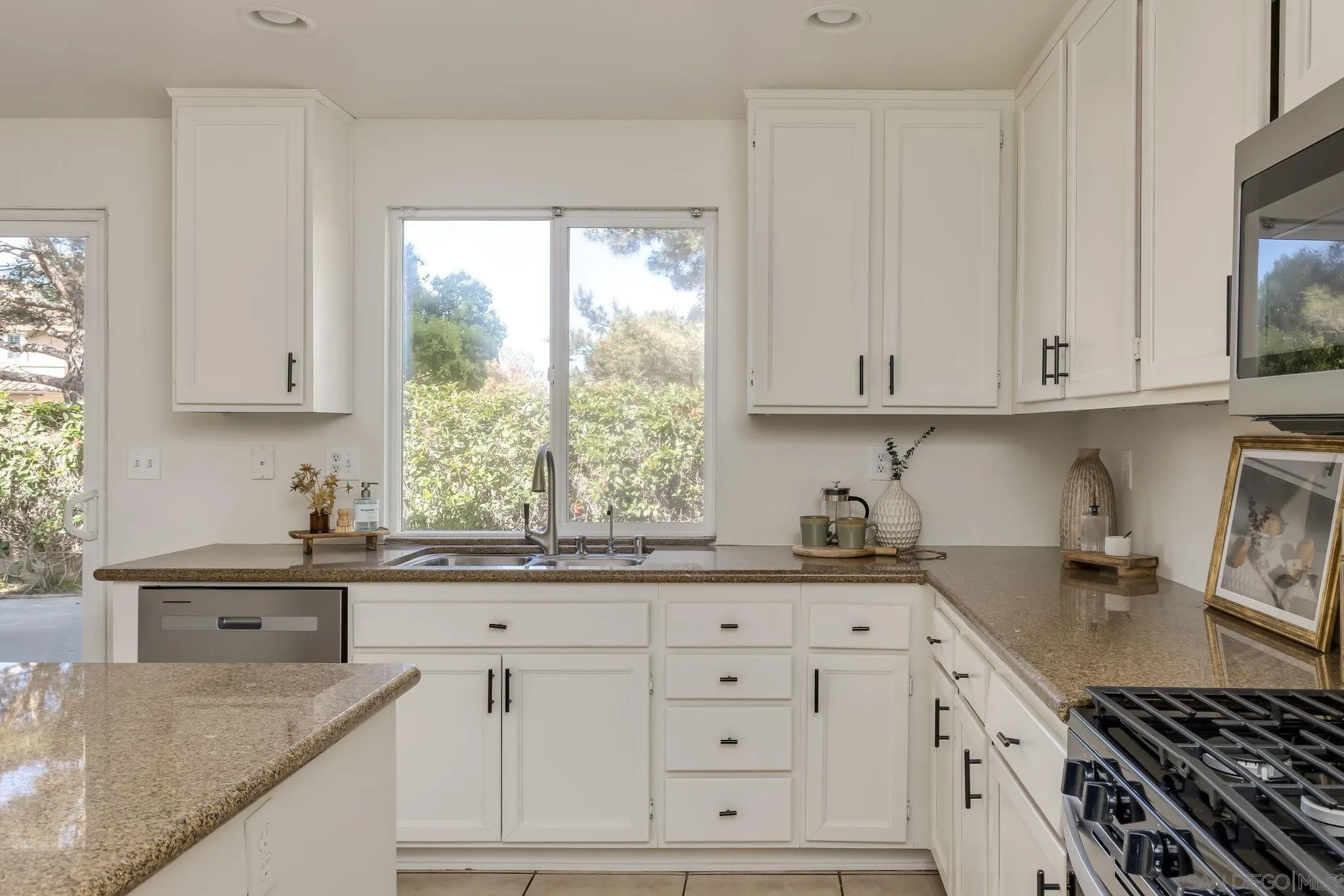 1589 Laurel Circle Vista, CA 92081 - Photo 8 of 31 a kitchen with granite countertop a sink a stove and cabinets