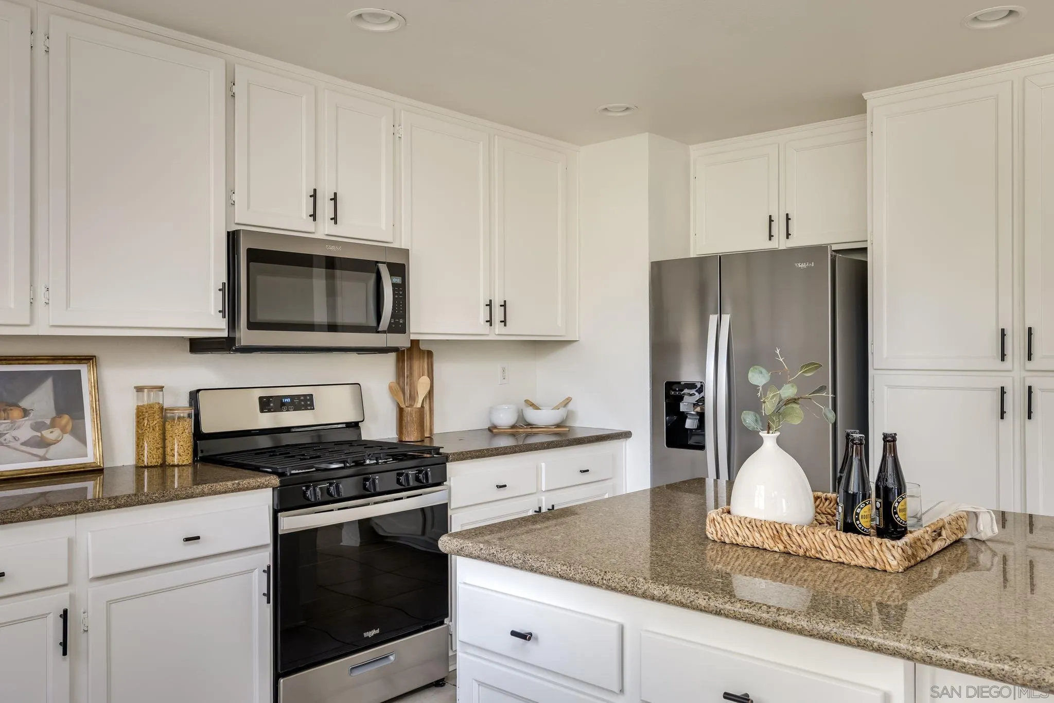 1589 Laurel Circle Vista, CA 92081 - Photo 9 of 31 a kitchen with granite countertop white cabinets and stainless steel appliances