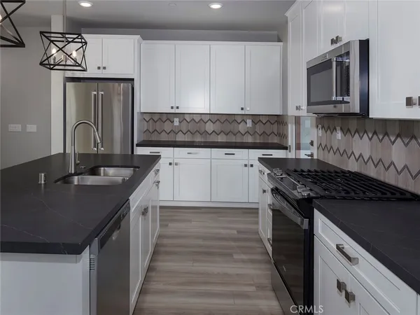 a kitchen with kitchen island granite countertop a sink stove and cabinets