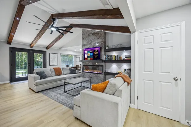 a living room with furniture a ceiling fan and a entryway