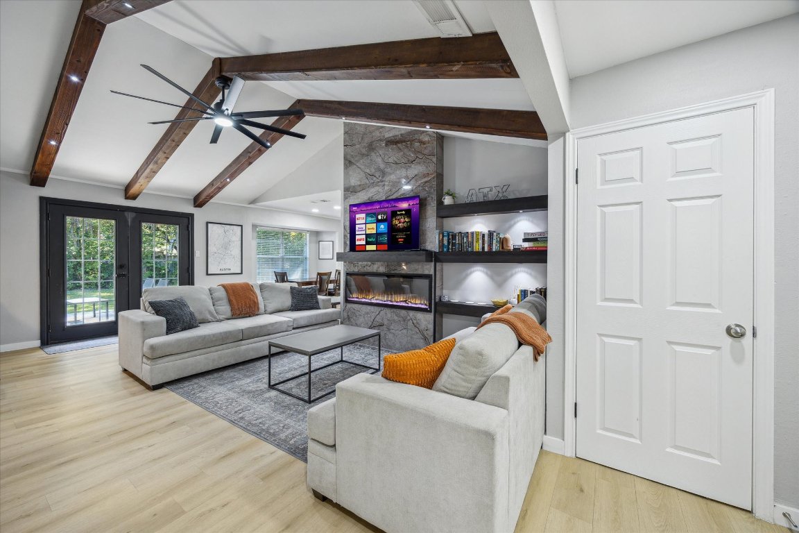 a living room with furniture a ceiling fan and a entryway