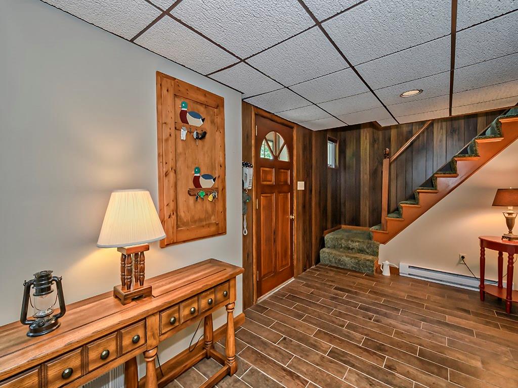 413 Spring St Extension Mars, PA 16046 - Photo 21 of 22 Family Room 27 Ft. X 13 Ft. with A Wood Burning Fireplace. There is an insert installed with a heatilator, this can be removed if you prefer an open style fireplace. Gorgeous Porcelain Tile Plank Flooring. There is a Full Bathroom right around the Corner.