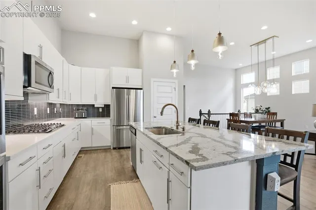 a kitchen with a sink stove cabinets and refrigerator