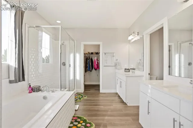 a bathroom with a tub a sink and a large mirror