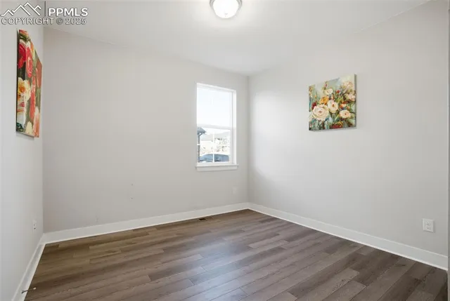 an empty room with wooden floor and window