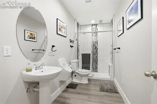 a bathroom with a sink a toilet and shower