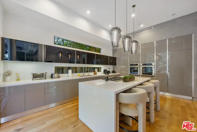 a kitchen with stainless steel appliances granite countertop a sink and a refrigerator