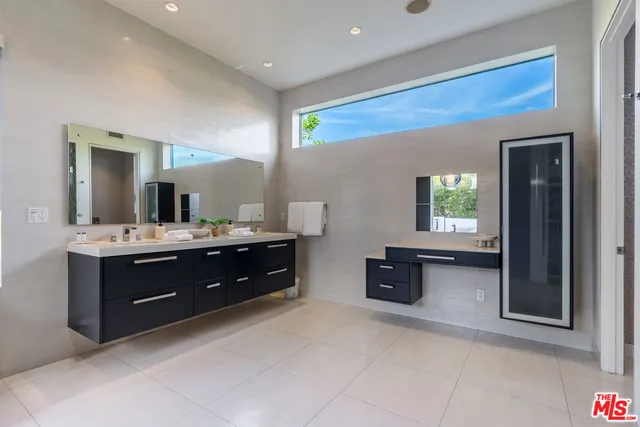 a spacious bathroom with a vanity a sink a mirror and a bathtub