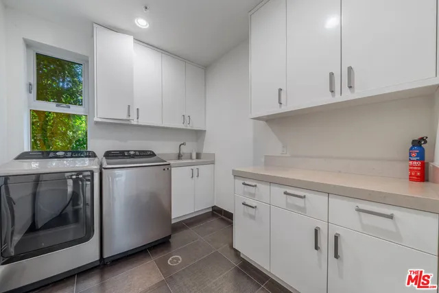 a kitchen with cabinets appliances a sink and a window