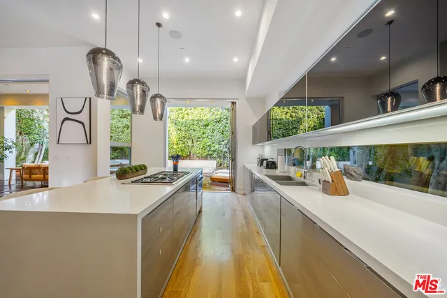 a kitchen with stainless steel appliances a sink a stove and a wooden floors