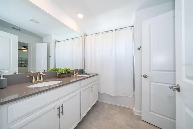 a bathroom with double vanity sink and a mirror