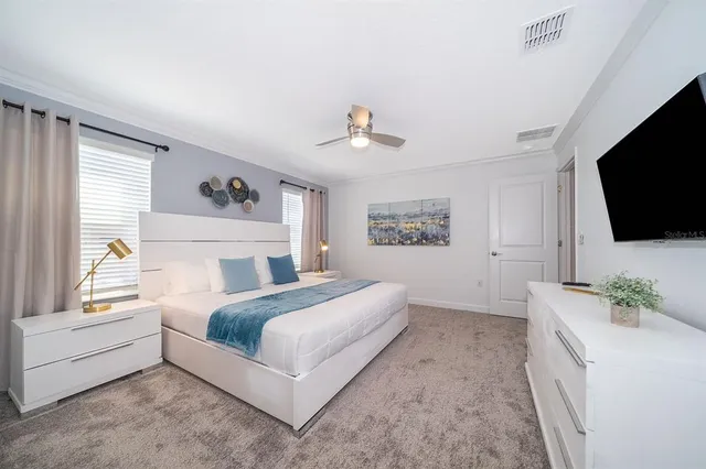 a spacious bedroom with a large bed and a flat screen tv