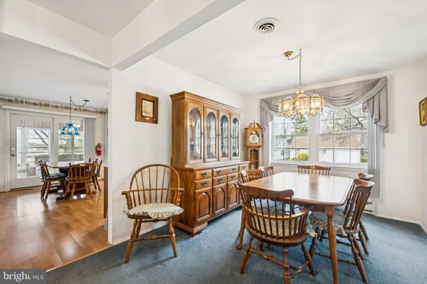 a dining room with furniture window and wooden floor