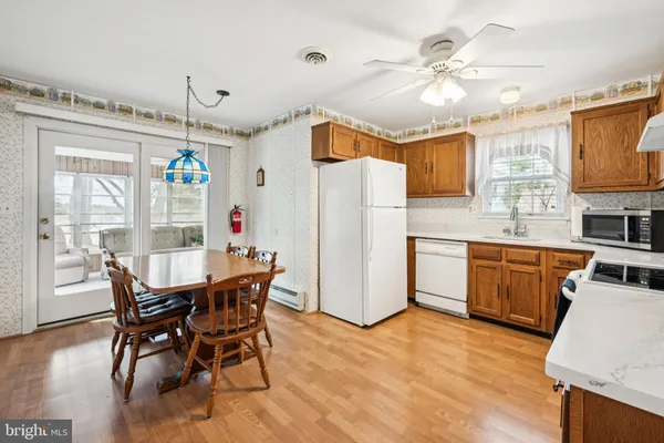 a dining table chair a refrigerator and a dining table with wooden floor