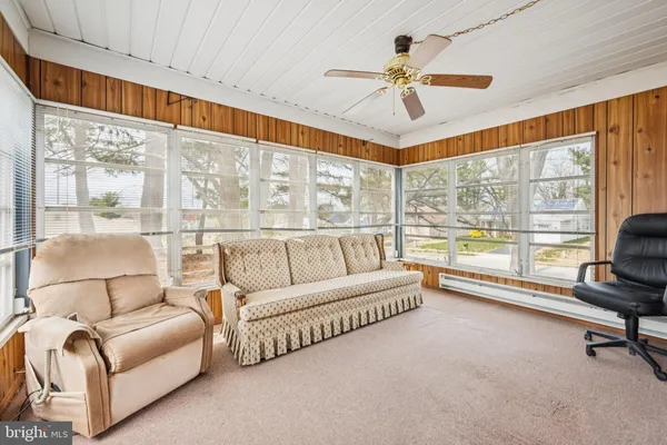 a living room with furniture and a large window with balcony view