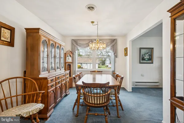 a dining room with furniture a chandelier and window