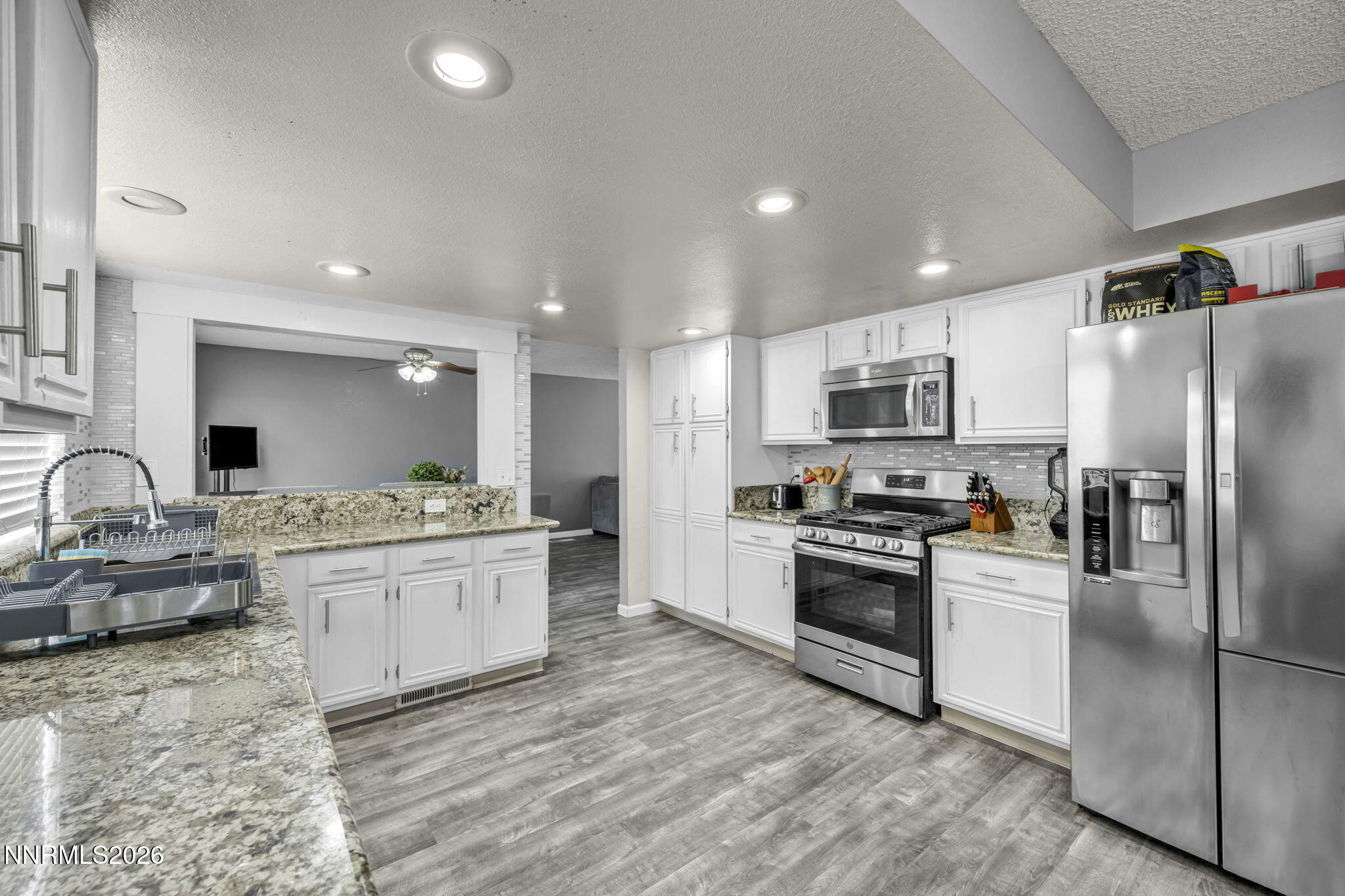 8655 Silver Shores Drive Reno, NV 89506 - Photo 11 of 42 a kitchen with stainless steel appliances kitchen island granite countertop a stove and a sink