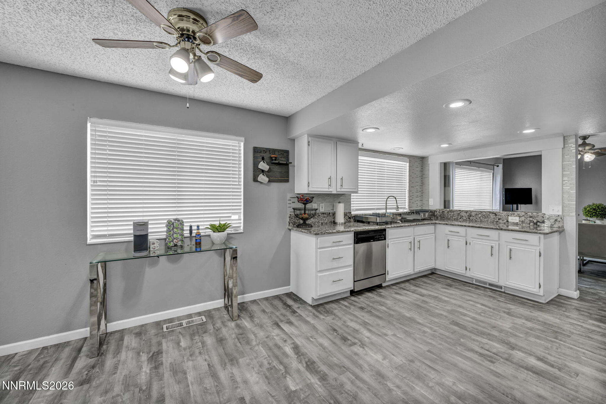 8655 Silver Shores Drive Reno, NV 89506 - Photo 13 of 42 a open kitchen with granite countertop a stove top oven a sink dishwasher and white cabinets with wooden floor