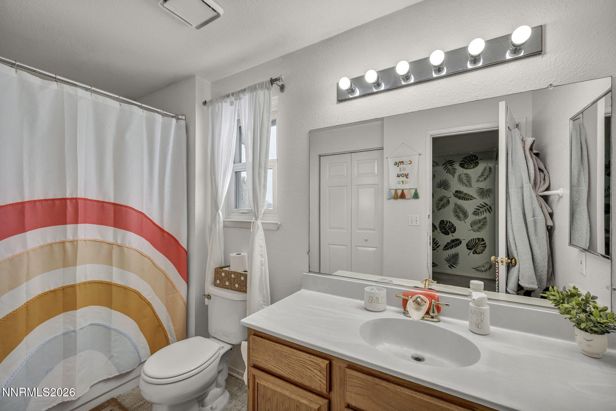 8655 Silver Shores Drive Reno, NV 89506 - Photo 28 of 42 a bathroom with a sink a toilet a mirror and shower curtain