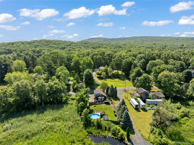 an aerial view of residential houses with outdoor space and trees