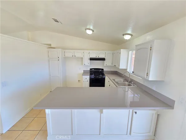 a kitchen with kitchen island a counter top space cabinets and stainless steel appliances