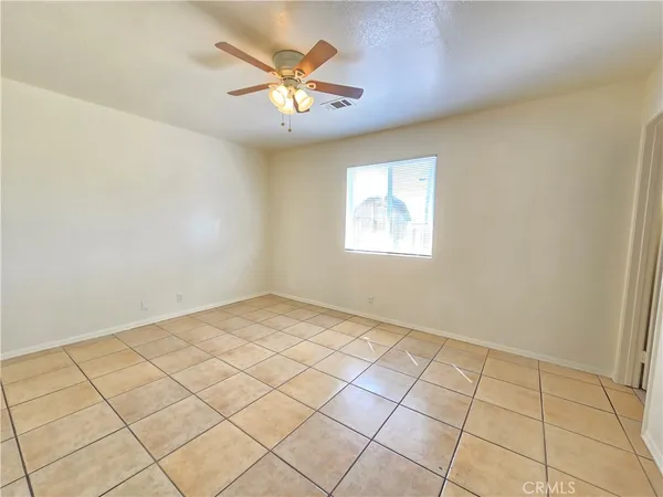 a view of an empty room with a fireplace and a window