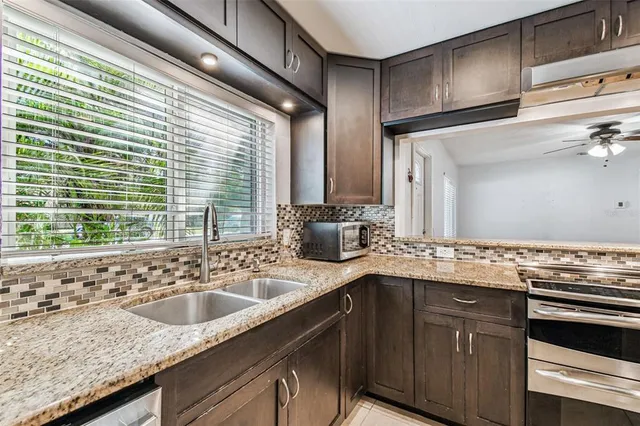 a kitchen with granite countertop a sink and a stove