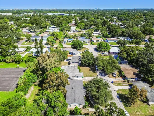 an aerial view of residential houses with outdoor space and trees
