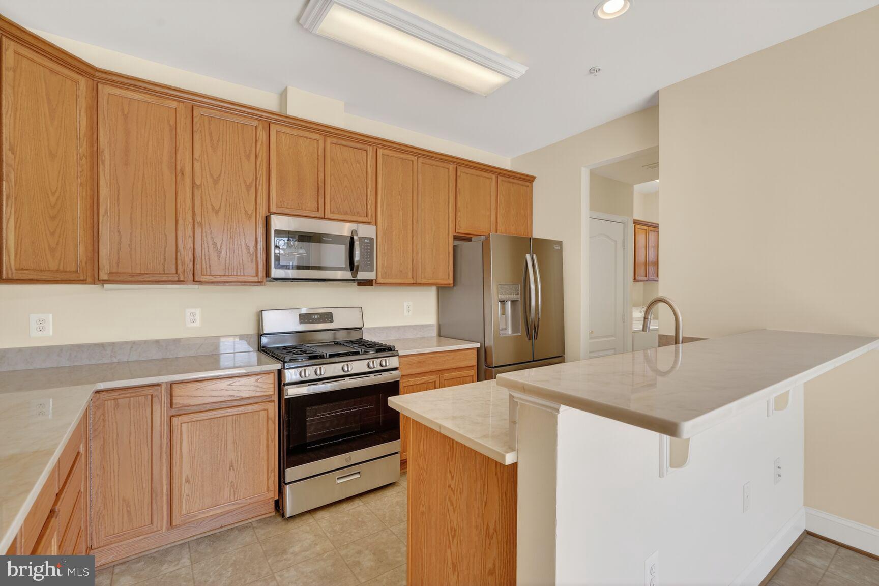 13210 Rabbit Chase Road Laurel, MD 20707 - Photo 11 of 40 a kitchen with stainless steel appliances granite countertop a sink stove and refrigerator