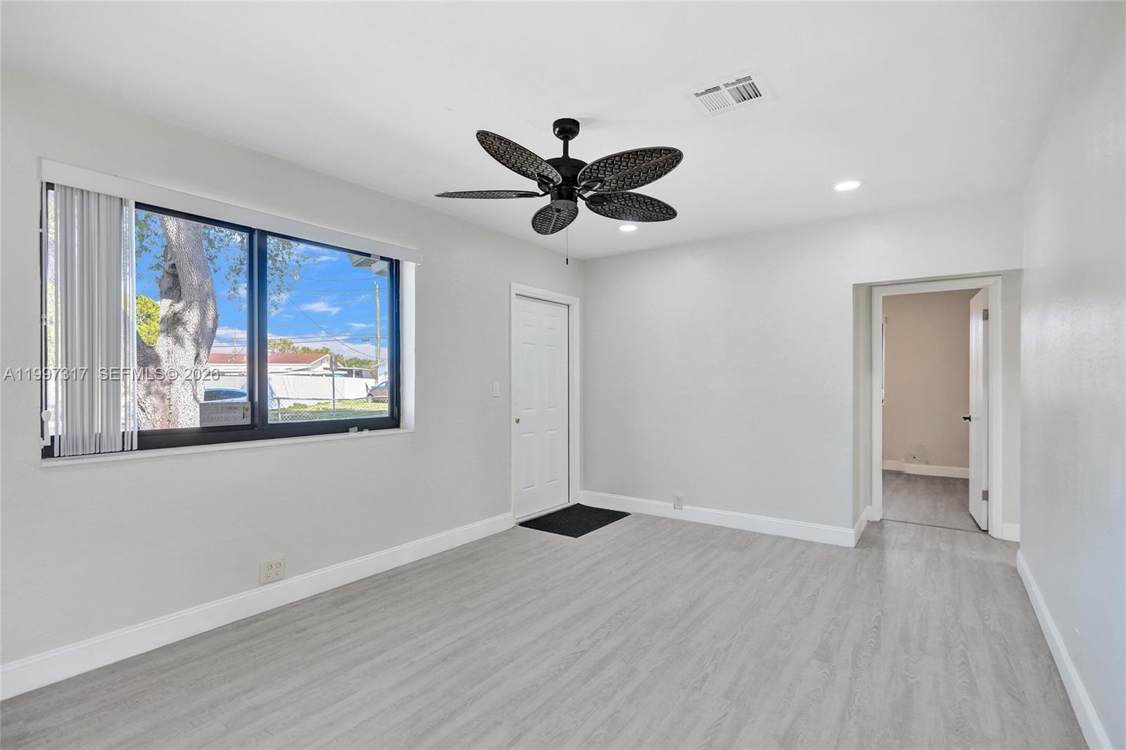136 Miami Gardens Road West Park, FL 33023 - Photo 12 of 44 wooden floor in an empty room with a window
