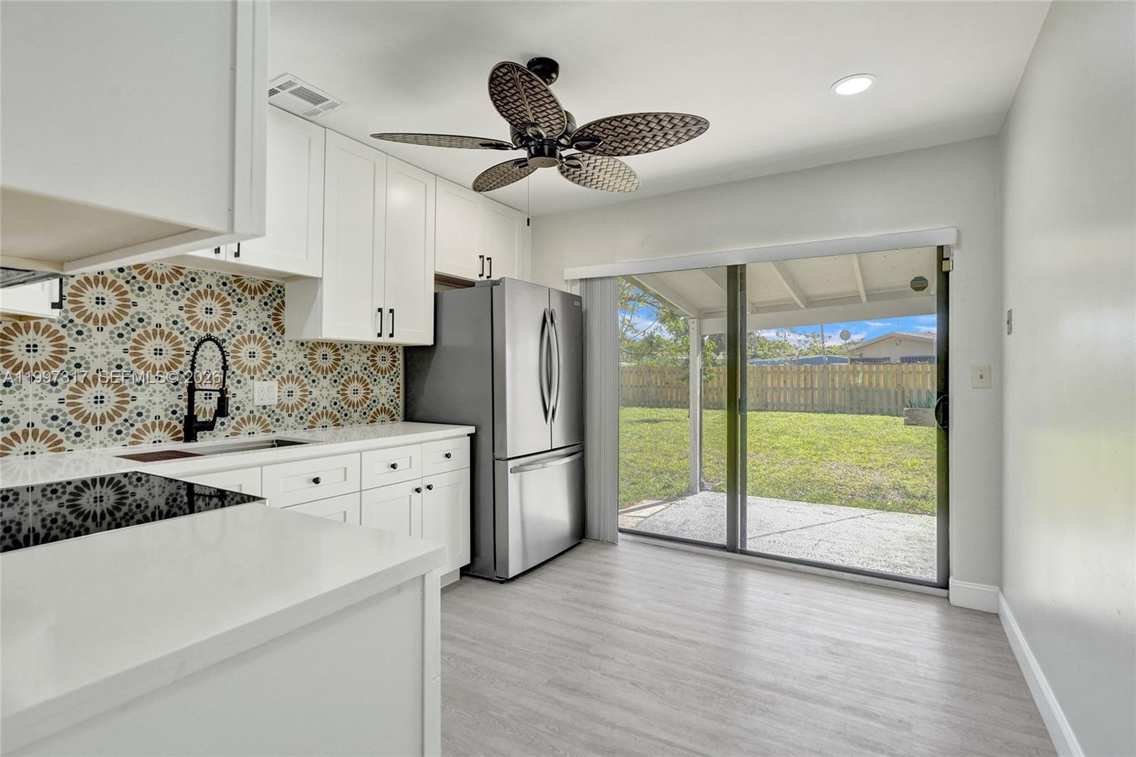 136 Miami Gardens Road West Park, FL 33023 - Photo 18 of 44 a open kitchen with a refrigerator a sink and wooden floor