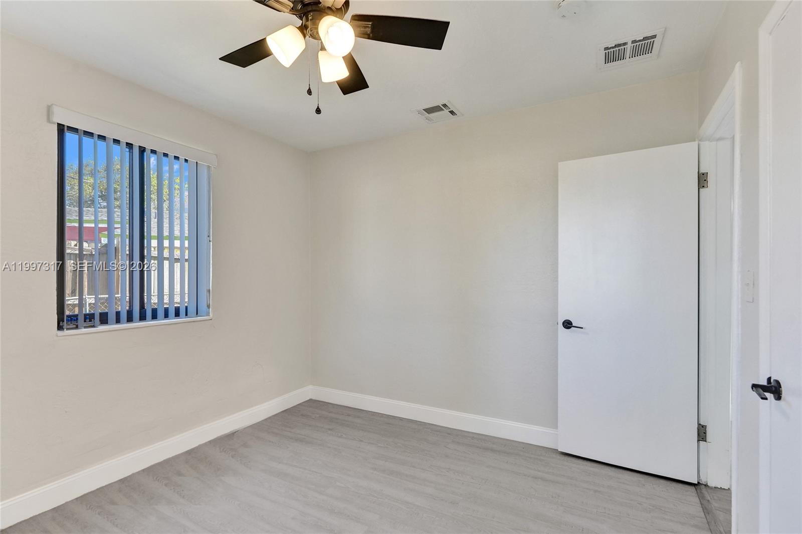 136 Miami Gardens Road West Park, FL 33023 - Photo 26 of 44 wooden floor in an empty room with a window