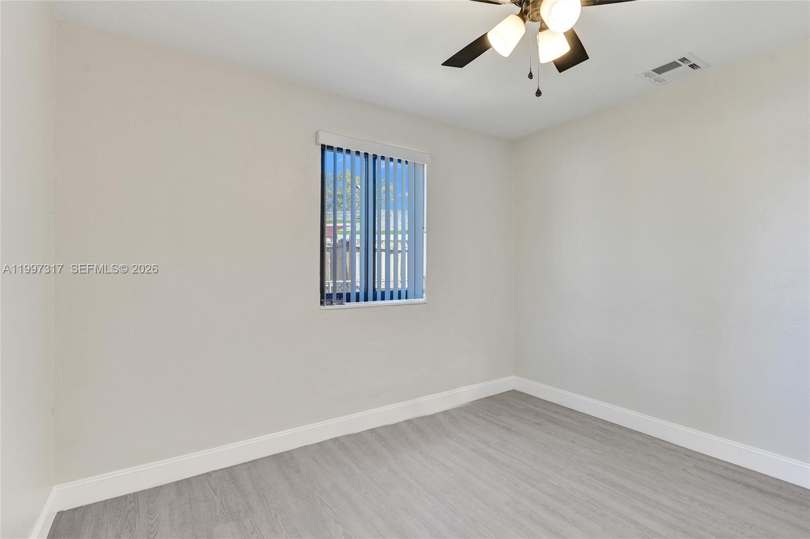 136 Miami Gardens Road West Park, FL 33023 - Photo 27 of 44 wooden floor in an empty room with a window