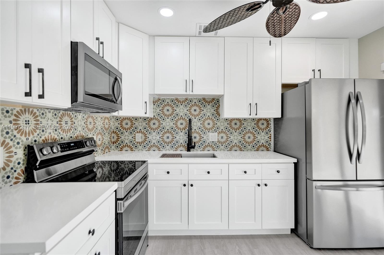 136 Miami Gardens Road West Park, FL 33023 - Photo 3 of 44 a kitchen with stainless steel appliances granite countertop a refrigerator sink stove and cabinets