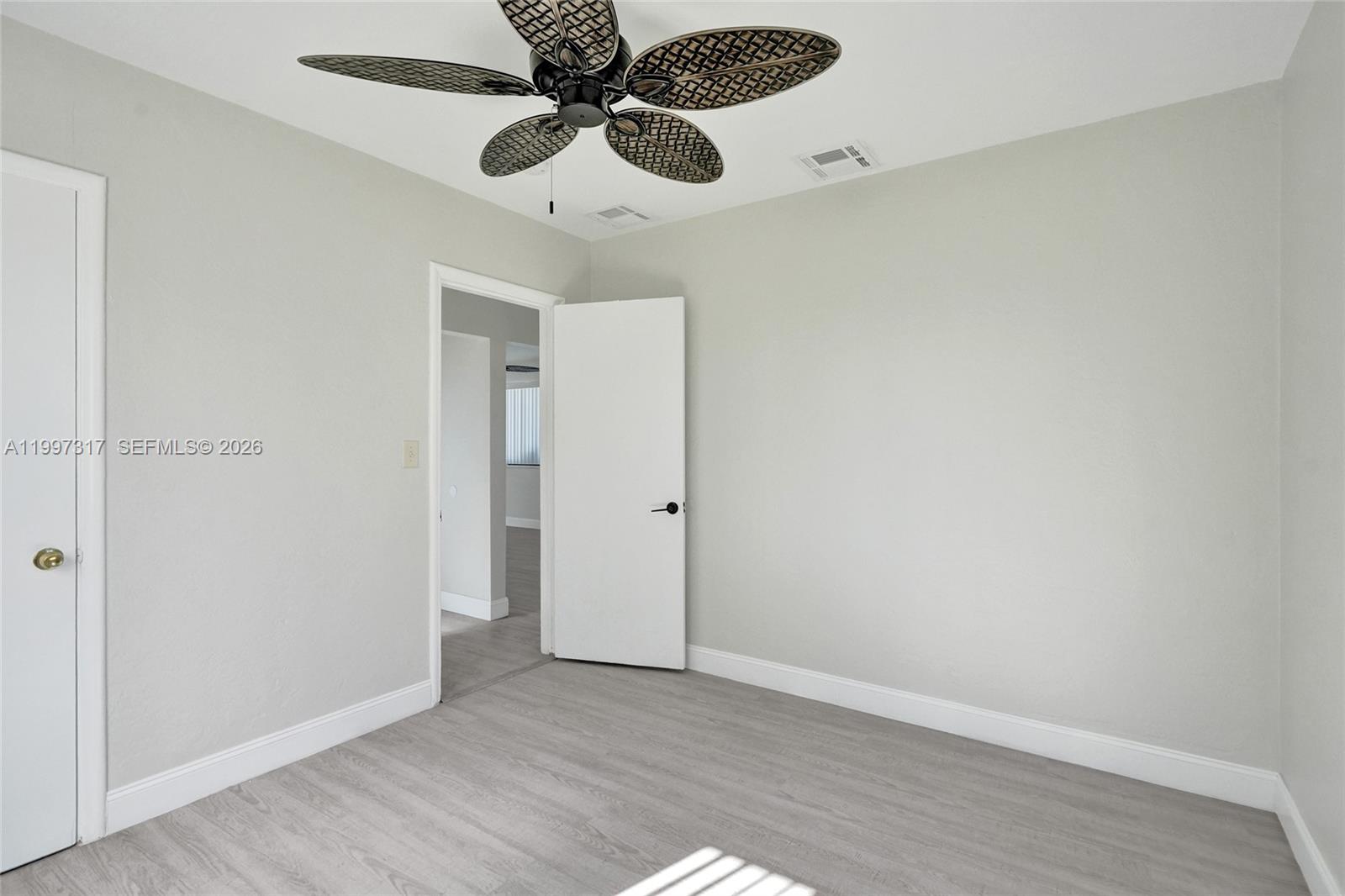 136 Miami Gardens Road West Park, FL 33023 - Photo 31 of 44 an empty room with wooden floor closet and fan