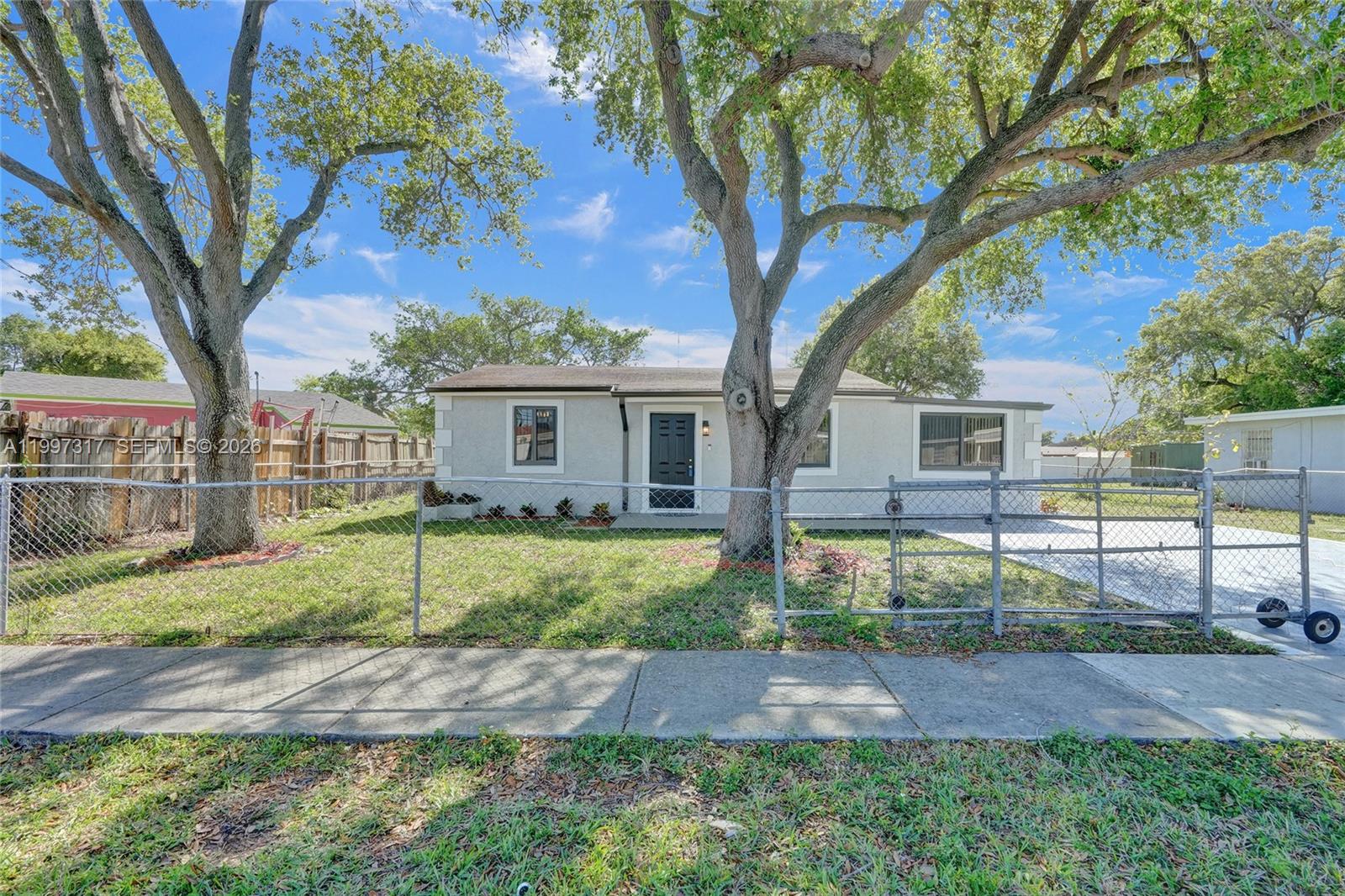 136 Miami Gardens Road West Park, FL 33023 - Photo 37 of 44 a view of a yard in front of a house with large tree