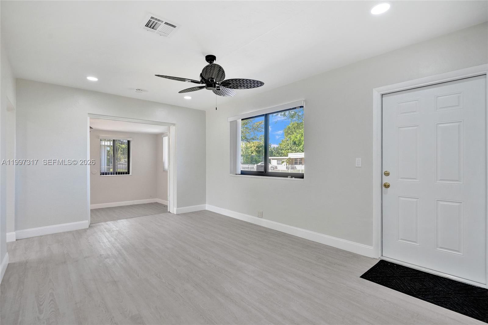136 Miami Gardens Road West Park, FL 33023 - Photo 10 of 44 a view of an empty room with window and wooden floor