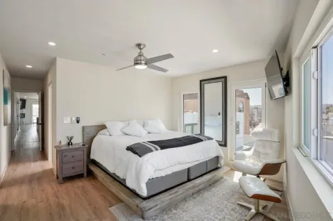 a bedroom with a bed window and a flat screen tv