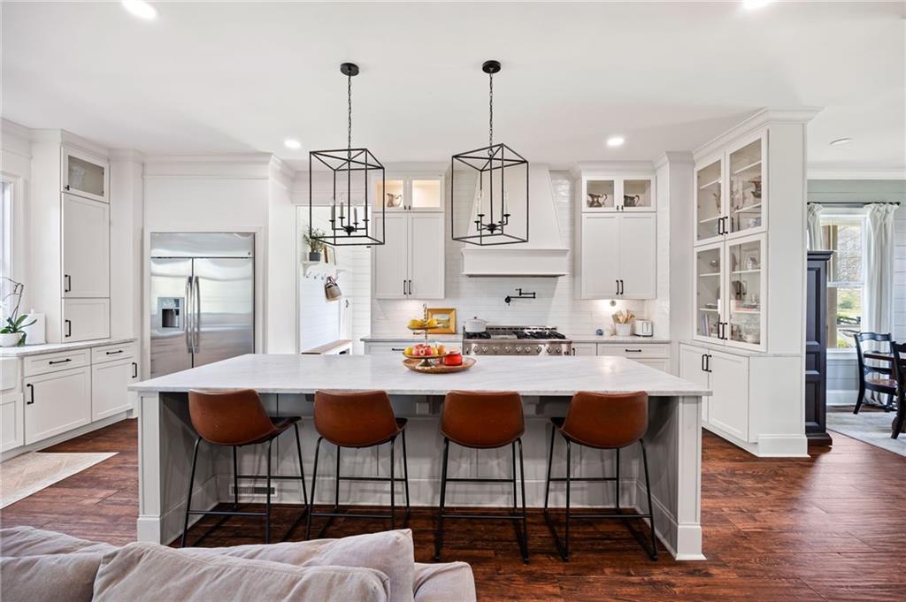 7093 Vaughn Road Woodstock, GA 30188 - Photo 26 of 86 a kitchen with stainless steel appliances a dining table chairs and wooden floor